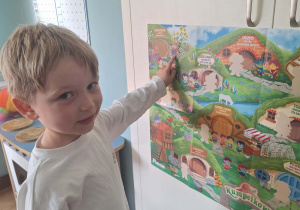 Chłopiec pokazuje mapę Wioski Kumplików