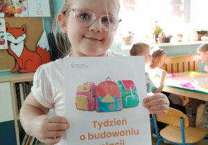 Dziewczynka trzyma ilustracje