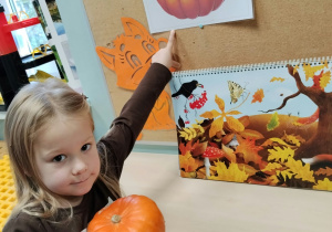 Dziewczynka wyszukała dynię z ilustracji w sali