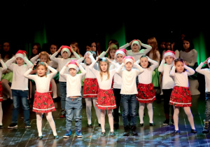 Dzieci z grupy Biedroneczki na scenie KDK podczas wykonywania piosenki "Mikołaj i katar"
