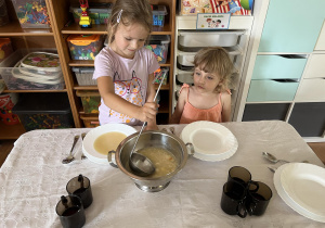 Dzieci samodzielnie nalewają zupę.