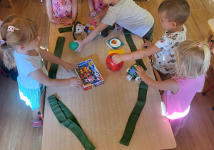 Dzieci układają do pętli małe zabawki.