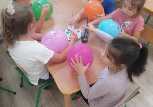 Dzieci malują balony.