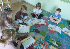 Dzieci pracują na dywanie.