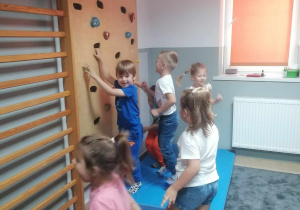 Dzieci wspinają się po ściance.
