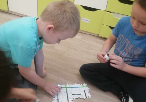 Dzieci budują drogę z puzzli.