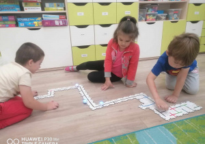 Dzieci budują drogę z puzzli.