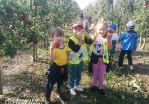 Dzieci trzymają jabłka.