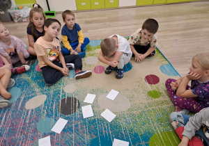 Dzieci bawią się na dywanie.