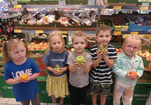 Dzieci pozują z owocami.
