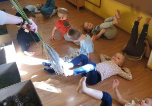 Dzieci uczestniczą w zabawie uwrażliwiającej zmysł dotyku