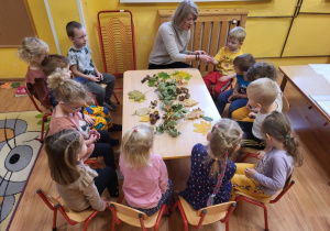 Dzieci na zajęciach zapoznają się z wyglądem liści z drzew rosnąch w ogrodzie przedszkolnym