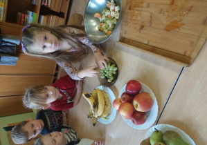 Dzieci wykonują sałatkę owocową.