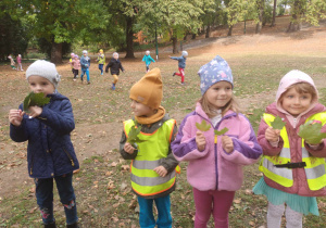 Dzieci trzymają kolorowe liście.
