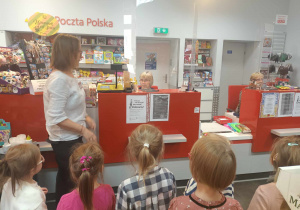 Dzieci na wycieczce w urzędzie pocztowym.