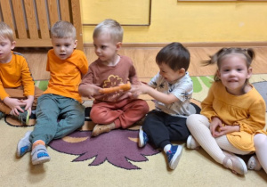 Dzieci poznają marchewkę za pomocą zmysłów: dotyku, węchu.