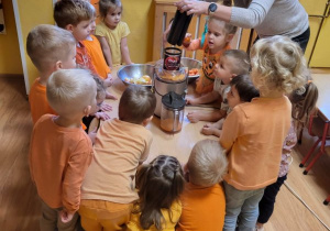 Dzieci z panią Małgosią przygotowują sok z marchewki.