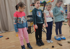 Czworo dzieci stoi przy instrumentach muzycznych