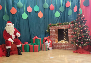 Mikołaj czeka z prezentami na dzieci.