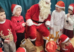 Mikołaj rozmawia z dziećmi .