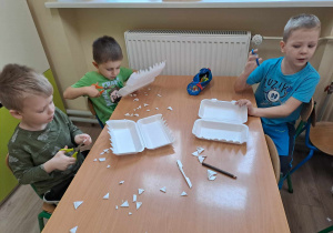 Dzieci pracują przy stolikach.