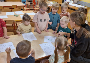 Pani Olga prezentuje dzieciom sposób wykonania choinki.