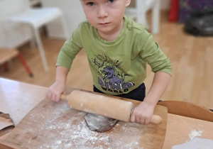 Chłopiec wałkuje ciasto.