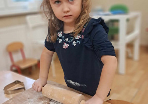 Dziewczynka wałkuje ciasto.