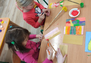Dzieci malują malują farbami.