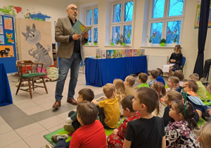 Autor czyta dzieciom książkę.