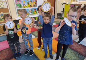 Dzieci prezentują wykonane przez siebie zegary.
