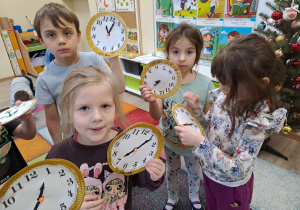 Dzieci prezentują wykonane przez siebie zegary.