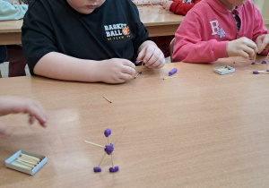 Dzieci tworzą konstrukcje z zapałek i plasteliny