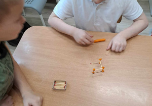 Dzieci tworzą konstrukcje z zapałek i plasteliny