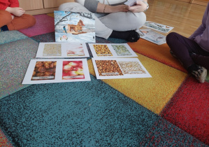 Dzieci oglądają plansze na dywanie