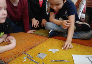 Dzieci układają robota Necia z poszczególnych elementów.