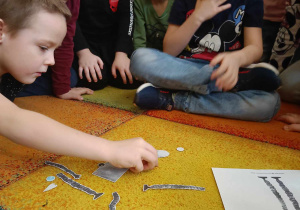 Dzieci układają robota Necia z poszczególnych elementów.