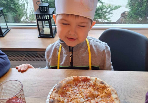 Dzieci biorą udział w warsztatach z robienia pizzy.