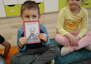 Chłopiec prezentuje ilustrację z jednym z zagrożeń.