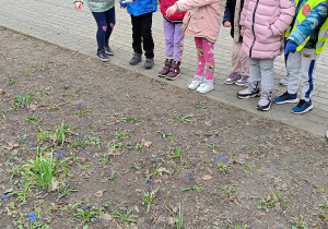 Dzieci pokazuja znalezione kwiaty.