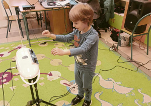 Chłopiec gra na instrumencie muzycznym.