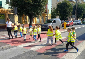 Dzieci bezpiecznie przechodzą przez jezdnię.