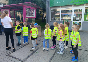 Dzieci poznaja zasady zachowania się na przystanku autobusowym.