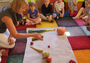 Dzieci obserwują , które z warzyw turlają się po powierzchni.