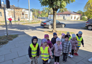 Dzieci stoją na chodniku przy przejściu dla pieszych