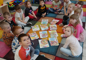 Dzieci siedzą w kole, poznają temat tolerancji do drugiego człowieka.