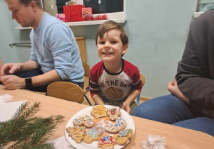 Chłopiec prezentuje swoje pierniczki.