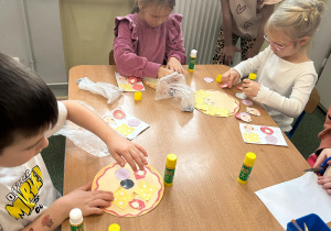 Dzieci układają zakupione produkty na pizzy.