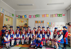 24 dzieci pozuje do grupowego zdjęcia w strojach do kujawiaka.