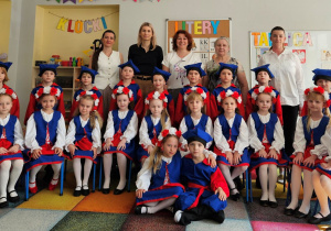 24 dzieci wraz z nauczycielkami, Dyrektorem i Wicedyrektorem pozuje do grupowego zdjęcia w strojach do kujawiaka.